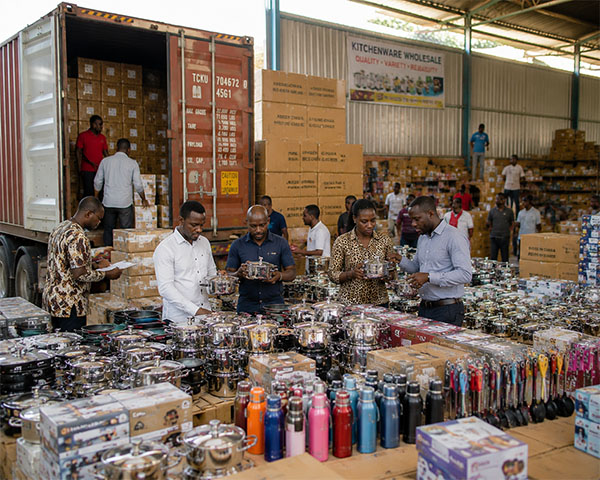 African kitchenware importers are inspecting containers of stainless steel kitchenware sets from China in their warehouses.